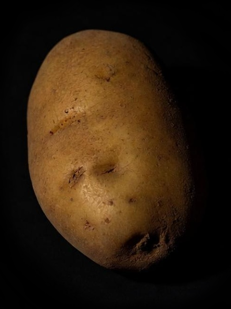 A dramatically lit potato floating in black empty space
